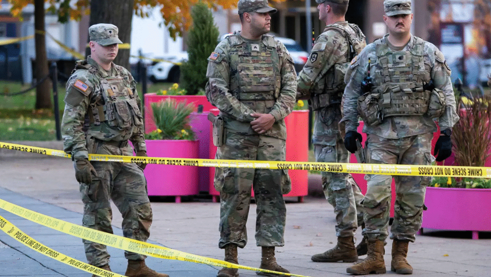 National Guard members stand together behind yellow tape, after two National Guard members were shot near the White House in Washington, DC, US on November 26. — Reuters