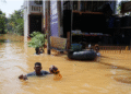 People wade through a flooded street, following Cyclone Ditwah in Kelaniya, Sri Lanka [Thilina Kaluthotage/Reuters]