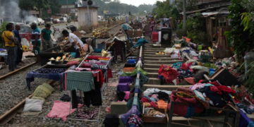 KANDY: People affected by floods in Sri Lanka collect their belongings from the railway tracks after drying them.—Reuters
