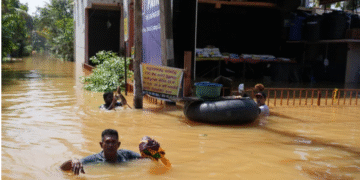 People wade through a flooded street, following Cyclone Ditwah in Kelaniya, Sri Lanka [Thilina Kaluthotage/Reuters]