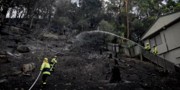 Firefighters work at the site where bushfire destroyed homes along Glenrock Parade, in Koolewong on the Central Coast of New South Wales, Australia