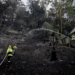 Firefighters work at the site where bushfire destroyed homes along Glenrock Parade, in Koolewong on the Central Coast of New South Wales, Australia
