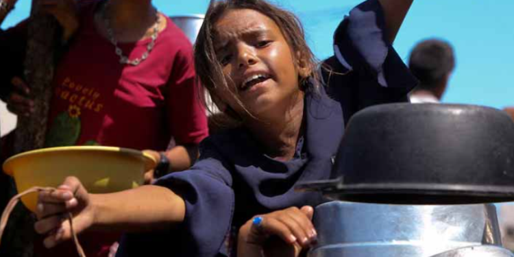 A Palestinian girl gestures as she waits to receive food from a charity kitchen, amid a hunger crisis, in Khan Younis, southern Gaza Strip. — Reuters